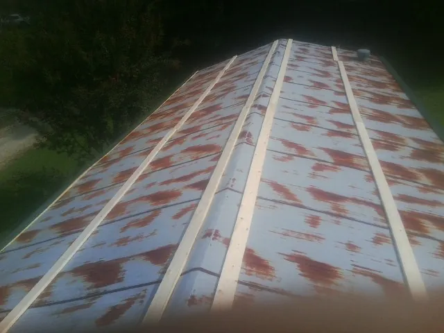 Rusted metal roof panels with new wood purlins before replacement — Storm Damage Roof Repair in Grenada by Roofing Brothers