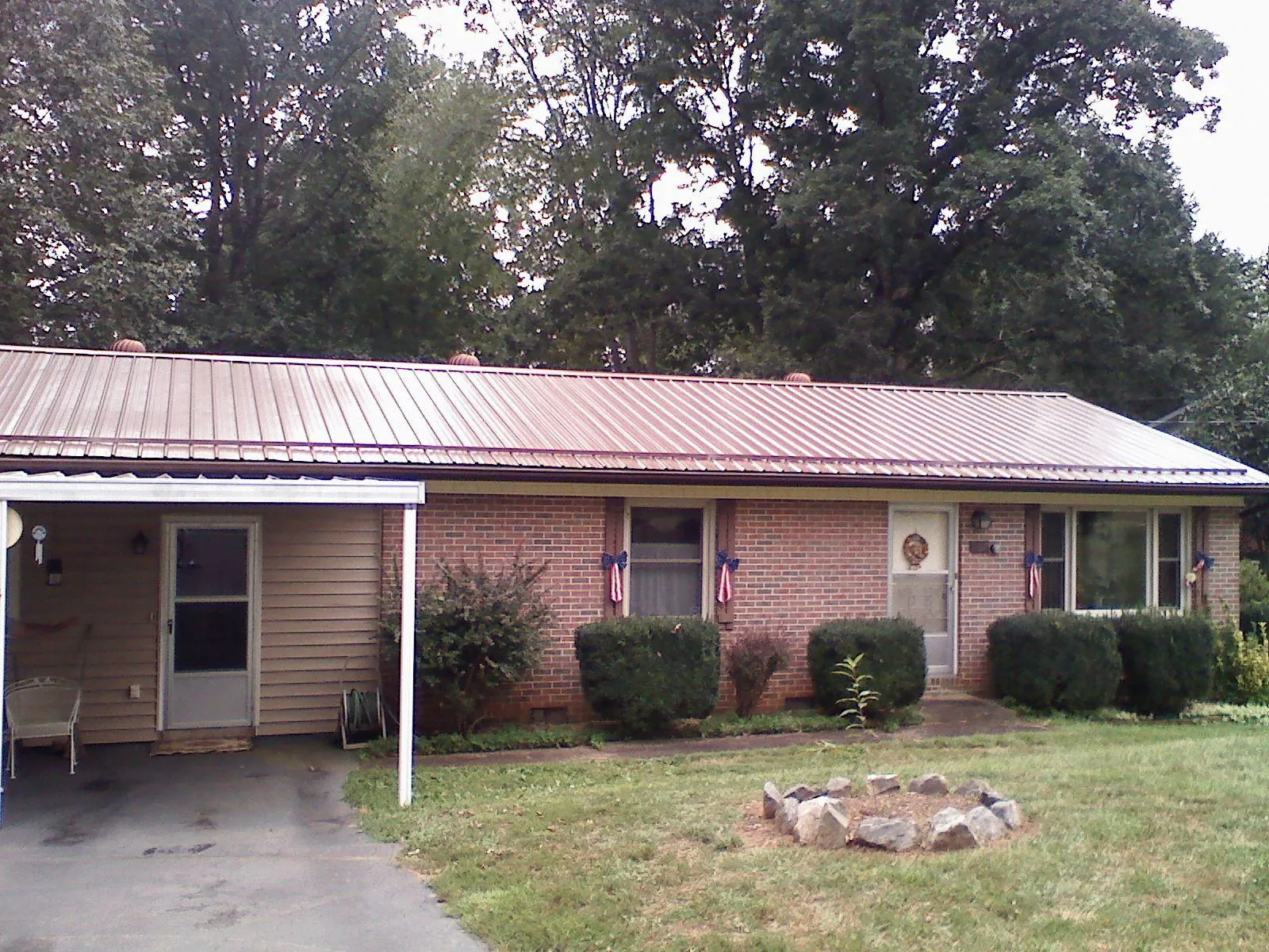 Bronze metal roof and carport on a brick ranch home — Roof Repair work by our crew in Grenada